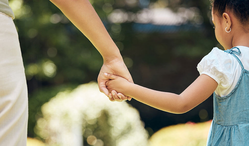 our-teamCropped-shot-of-a-little-girl-holding-her-mothers-hand-while-walking-outside